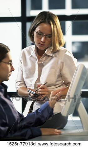 Stock Image - Businesswoman using a hand held device. Fotosearch