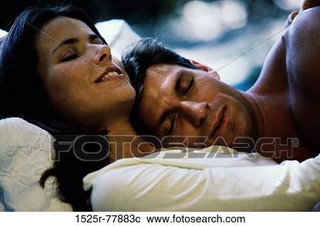 Close-up of a mid adult couple embracing in bed View Large Photo Image Stock Image - Close-up of a mid adult couple embracing in bed. Fotosearch
