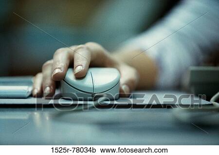 Stock Image - Close-up of a person's hand holding a computer mouse. Fotosearch