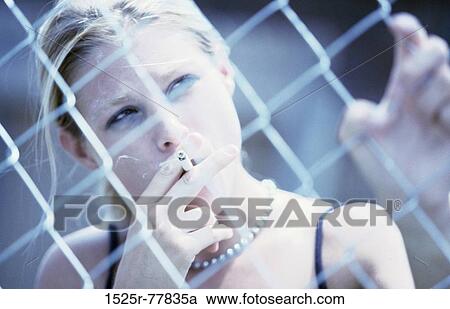 Stock Image - fence, tobacco, straightforward, puffing, people, smoke, cigarette. Fotosearch