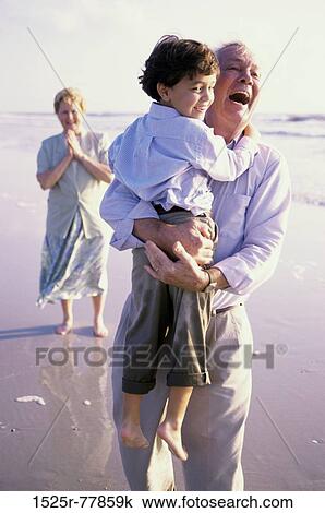 Grandfather carrying his grandson on the beach View Large Photo Image Stock Image - Grandfather carrying his grandson on the beach. Fotosearch