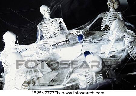 Group of human skeletons sitting around a table View Large Photo Image Stock Image - Group of human skeletons sitting around a table. Fotosearch