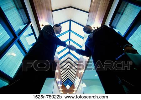 Low angle view of two businessmen shaking hands View Large Photo Image Stock Image - Low angle view of two businessmen shaking hands. Fotosearch