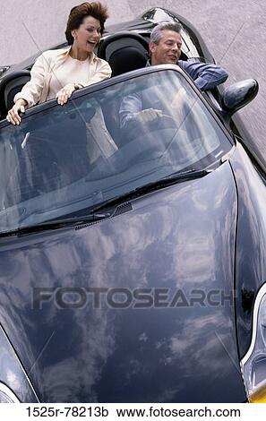 Mid adult couple in a convertible car View Large Photo Image Stock Image - Mid adult couple in a convertible car. Fotosearch