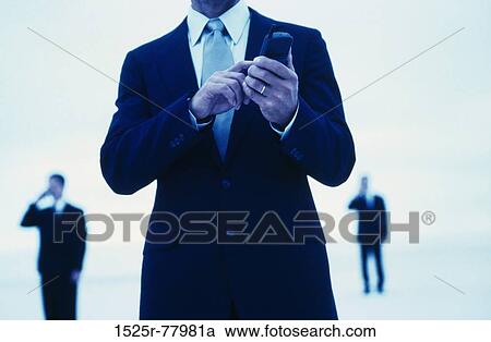 Stock Image - Mid section view of a businessman operating a mobile phone. Fotosearch