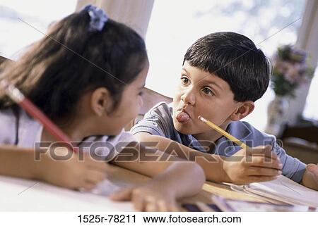 Stock Image - people, papers, Hispanic, homework, tongue, writing. Fotosearch
