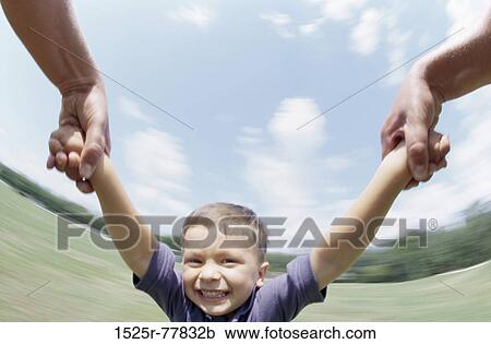 Person swinging a boy by his arms View Large Photo Image Stock Image - Person swinging a boy by his arms. Fotosearch