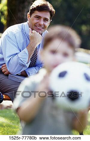 Portrait of a father sitting with a laptop looking at his son View Large Photo Image Stock Image - Portrait of a father sitting with a laptop looking at his son. Fotosearch