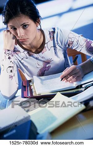 Portrait of a teenage sitting at a desk with books View Large Photo Image Stock Image - Portrait of a teenage sitting at a desk with books. Fotosearch