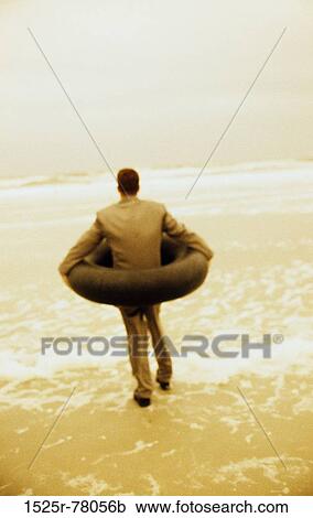 Rear view of a businessman wearing an inner tube around him at the beach View Large Photo Image Stock Image - Rear view of a businessman wearing an inner tube around him at the beach. Fotosearch