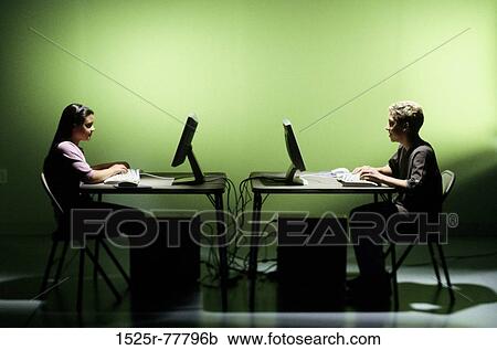 Stock Image - Side profile of a teenage girl and a teenage boy using computers. Fotosearch