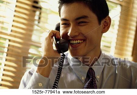 Stock Image - smiling, telephone, talking, Asian, listening. Fotosearch