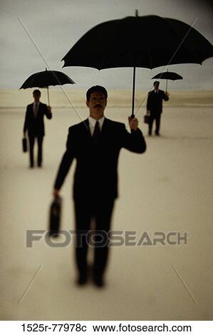 Three businessmen holding umbrellas in the desert View Large Photo Image Stock Image - Three businessmen holding umbrellas in the desert. Fotosearch