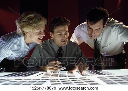 Two mid adult men and a mid adult woman looking at slides View Large Photo Image Stock Image - Two mid adult men and a mid adult woman looking at slides. Fotosearch
