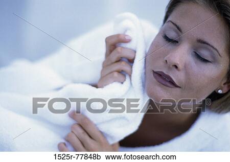 Young woman wiping her face with a towel View Large Photo Image Stock Image - Young woman wiping her face with a towel. Fotosearch