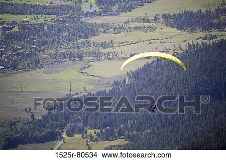 Aerial view of a person paragliding View Large Photo Image Picture - Aerial view of a person paragliding. Fotosearch