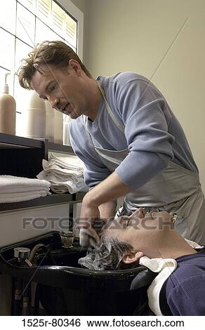 Barber washing hair of a young man View Large Photo Image Stock Photograph - Barber washing hair of a young man. Fotosearch