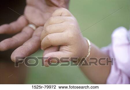 Close-up of a girl holding a person's finger View Large Photo Image Stock Image - Close-up of a girl holding a person's finger. Fotosearch