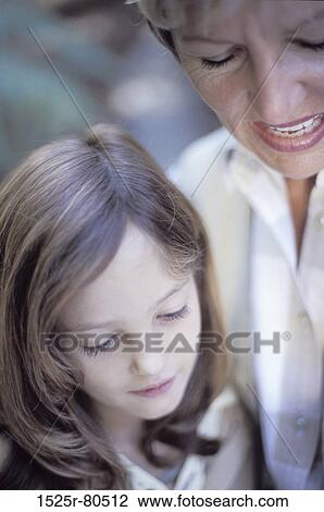 Close-up of a grandmother talking to her granddaughter View Large Photo Image Stock Image - Close-up of a grandmother talking to her granddaughter. Fotosearch