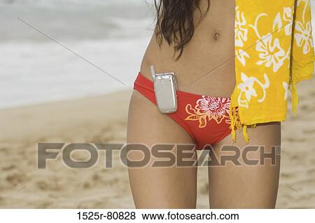 Close-up of a mobile phone hanging on the bikini bottom of a woman View Large Photo Image Stock Photo - Close-up of a mobile phone hanging on the bikini bottom of a woman. Fotosearch