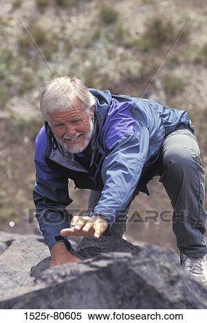 Stock Photography - Close-up of a senior man rock climbing. Fotosearch