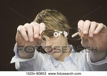 Close-up of a teenage boy showing eyeglasses View Large Photo Image Stock Image - Close-up of a teenage boy showing eyeglasses. Fotosearch