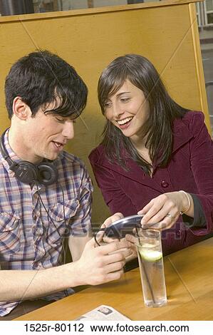 Close-up of a young couple holding an MP3 Player View Large Photo Image Stock Image - Close-up of a young couple holding an MP3 Player. Fotosearch
