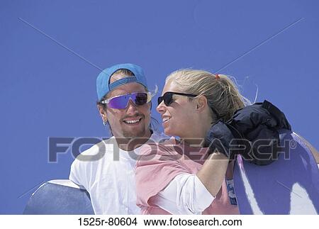 Close-up of a young couple holding snowboards View Large Photo Image Picture - Close-up of a young couple holding snowboards. Fotosearch