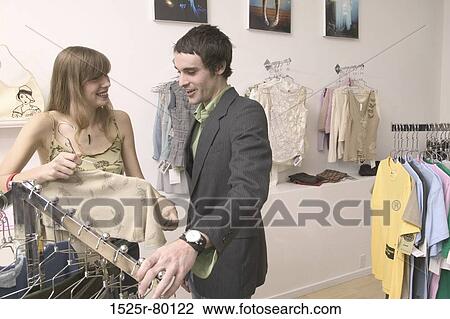 Close-up of a young couple talking to each other in a clothing store View Large Photo Image Stock Image - Close-up of a young couple talking to each other in a clothing store. Fotosearch