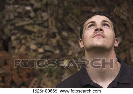 Close-up of a young man looking up View Large Photo Image Stock Photography - Close-up of a young man looking up. Fotosearch