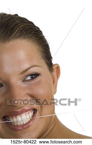 Close-up of a young woman flossing her teeth View Large Photo Image Stock Image - Close-up of a young woman flossing her teeth. Fotosearch