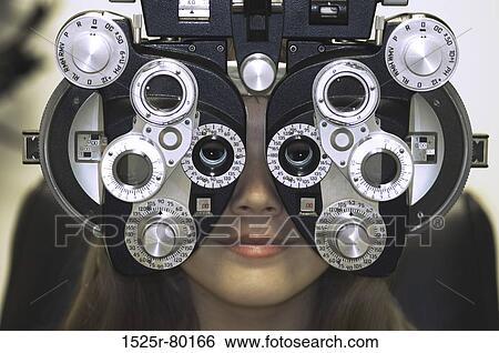 Close-up of a young woman getting an eye test with a phoropter View Large Photo Image Stock Photograph - Close-up of a young woman getting an eye test with a phoropter. Fotosearch