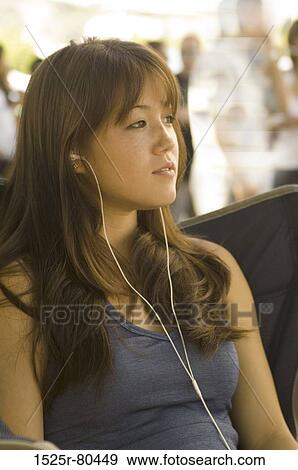 Close-up of a young woman listening to music View Large Photo Image Stock Photo - Close-up of a young woman listening to music. Fotosearch