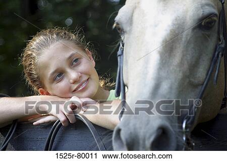 Close-up of a young woman looking at a horse View Large Photo Image Stock Image - Close-up of a young woman looking at a horse. Fotosearch