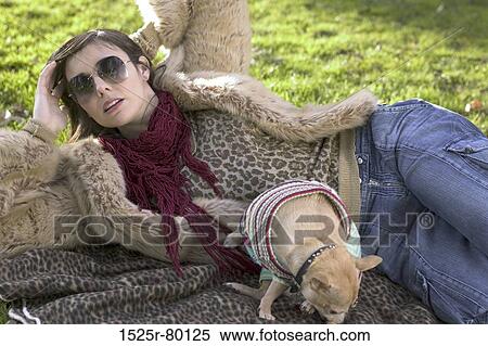 Close-up of a young woman lying on a picnic blanket behind a puppy View Large Photo Image Stock Photography - Close-up of a young woman lying on a picnic blanket behind a puppy. Fotosearch