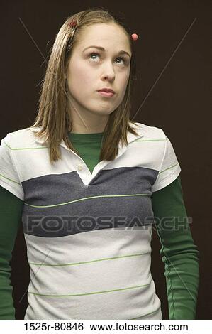 Close-up of a young woman thinking View Large Photo Image Stock Photograph - Close-up of a young woman thinking. Fotosearch