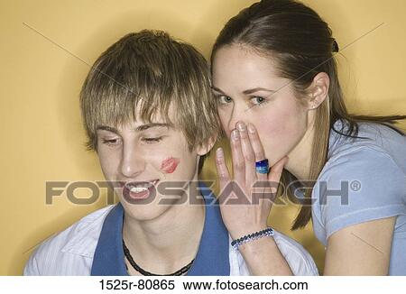 Close-up of a young woman whispering into a young man's ear View Large Photo Image Stock Photography - Close-up of a young woman whispering into a young man's ear. Fotosearch