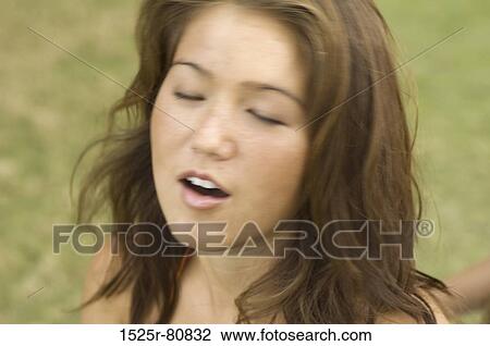Close-up of a young woman with her eyes closed View Large Photo Image Stock Image - Close-up of a young woman with her eyes closed. Fotosearch