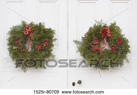 Stock Photo - Close-up of two Christmas wreaths on the door. Fotosearch