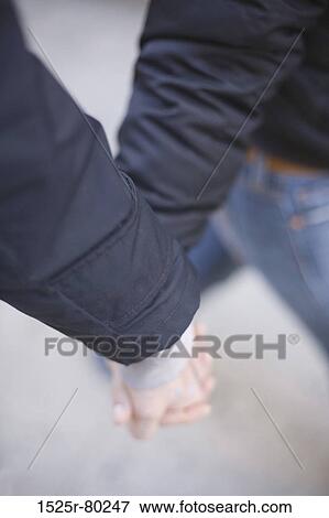 Close-up of two people holding hands and walking View Large Photo Image Stock Photo - Close-up of two people holding hands and walking. Fotosearch