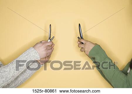 Close-up of two women's hands holding mobile phones View Large Photo Image Stock Image - Close-up of two women's hands holding mobile phones. Fotosearch