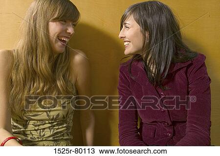 Close-up of two young women smiling and looking at each other View Large Photo Image Stock Image - Close-up of two young women smiling and looking at each other. Fotosearch