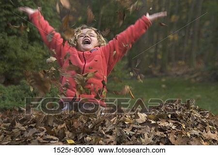 Girl playing with dry leaves in the park View Large Photo Image Stock Image - Girl playing with dry leaves in the park. Fotosearch