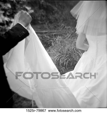 Groom holding the veil of a bride View Large Photo Image Stock Photo - Groom holding the veil of a bride. Fotosearch