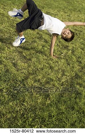 High angle view of a boy somersaulting on the grass View Large Photo Image Stock Image - High angle view of a boy somersaulting on the grass. Fotosearch