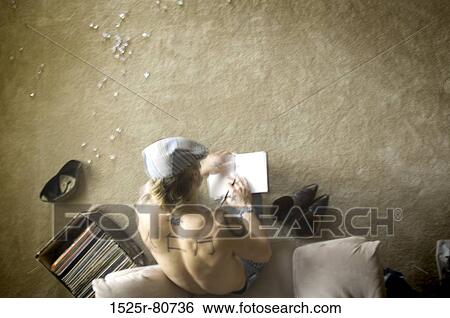 Stock Photograph - High angle view of a man writing on a notepad. Fotosearch