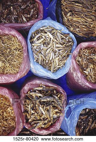 Stock Image - High angle view of dried fish in sacks. Fotosearch