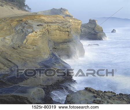 Stock Photo - High angle view of waves breaking on rocks at the coast. Fotosearch