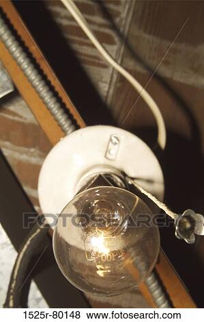 Low angle view of a light bulb lit up View Large Photo Image Stock Photo - Low angle view of a light bulb lit up. Fotosearch