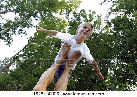 Low angle view of a person balancing a boy on his feet View Large Photo Image Stock Photograph - Low angle view of a person balancing a boy on his feet. Fotosearch